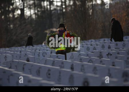 Un volontario raccoglie corone durante la cerimonia annuale di commemorazione Wreaths Across Canada al National Military Cemetery di Ottawa, Canada, il 7 dicembre 2014. Circa 3.000 corone furono poste sulle tombe di soldati, marinai e piloti che servirono il Canada. CANADA-OTTAWA-GHIRLANDE ATTRAVERSO IL CANADA-COMMEMORAZIONE DavidxKawai PUBLICATIONxNOTxINxCHN un volontario raccoglie ghirlande durante la cerimonia annuale di commemorazione Wreaths Across Canada AL National Military Cemetery di Ottawa Canada IL 7 dicembre 2014 circa 3 000 ghirlande sono state collocate SULLE tombe dei soldati marinai e piloti che hanno servito Canada C. Foto Stock