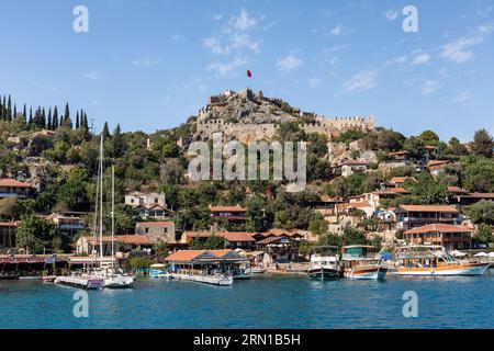 Villaggio e castello di Simena visti da un'imbarcazione turistica in arrivo, Simena, Kalekoy, Turchia Foto Stock