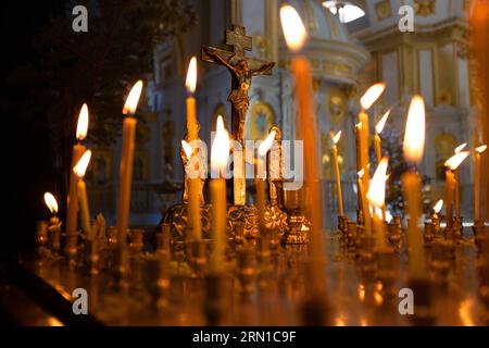 Funeraria Memorial posto in una chiesa ortodossa per rituale, candele sono accese per la posa. Su un tavolo quadrato di metallo - servizi requiem. Cristo su di lui w Foto Stock