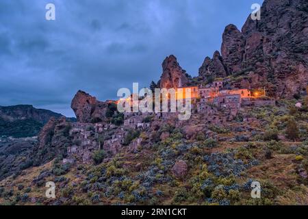 Il paese di Pentedattilo, danneggiato da un terremoto del 1785 e oggi città fantasma, situata sul Monte Calvario, illuminata di notte. Foto Stock