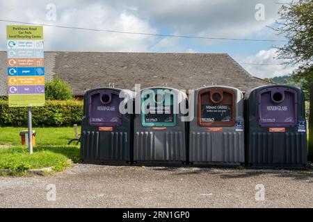 Punto di riciclaggio locale in un parcheggio del villaggio con contenitori per vetro di diversi colori, Inghilterra, Regno Unito Foto Stock