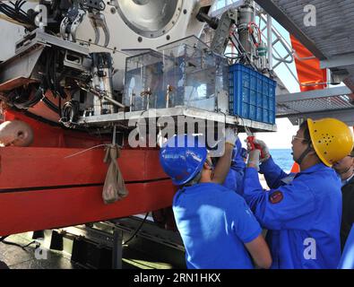 A BORDO DI XIANGYANGHONG 09, 2 gennaio 2015 -- gli scienziati scaricano campioni di fondali marini dal sommergibile cinese Jiaolong con equipaggio in alto mare sulla sua nave Xiangyanghong 09 nell'Oceano Indiano, 2 gennaio 2015. Jiaolong ha effettuato la prima immersione in una missione per studiare lo sfiato idrotermale attivo nell'Oceano Indiano sudoccidentale il 2 gennaio. Era la prima volta che il sommergibile prendeva il secondo gruppo di piloti tirocinanti in immersione, che aveva lo scopo di consentire ai tirocinanti di imparare alcune abilità di funzionamento sommergibile nello sfiato idrotermico attivo e raccogliere campioni di fluido idrotermico, solfuro, rocce, sedimen Foto Stock