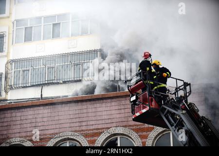 (150104) -- HARBIN, 4 gennaio 2015 -- i fumi aumentano da un magazzino bruciato presso il mercato della ceramica Beifangnanxun nel distretto di Daowai, Harbin, capitale della provincia di Heilongjiang nella Cina nordorientale, 4 gennaio 2014. Il magazzino di Harbin City, che ha ucciso 5 vigili del fuoco, non è ancora stato completamente spento, hanno detto i vigili del fuoco locali domenica. Alle 10:40 di domenica, un edificio residenziale vicino al magazzino stava ancora morendo. I soccorritori hanno detto che la fonte dell'incendio è stata difficile da determinare a causa della complessa struttura dell'edificio, e l'edificio è a rischio di crollare. Scontri a fuoco Foto Stock