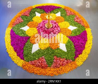 Rangoli di fiori tradizionali per Onam, festa del raccolto del Kerala in India. Motivi floreali con tappeti freschi realizzati per il festival indiano Foto Stock