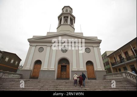 L'immagine scattata il 20 gennaio 2015 mostra i turisti che camminano di fronte alla chiesa di la Matriz nel settore del Barrio Puerto nella città di Valparaiso, Cile. A causa della sua ricchezza architettonica sviluppata nel XIX secolo, Valparaiso è stata dichiarata Patrimonio dell'Umanità nel 2013 dall'Organizzazione delle Nazioni Unite per l'educazione, la scienza e la cultura (UNESCO). Con le sue antiche case, edifici, chiese, vicoli, colline, gole, scale e ciottoli, Valparaiso fu una testimonianza singolare dell'inizio dell'era industriale del XIX secolo, quando la città divenne il porto principale delle coste del Pacifico meridionale. Jorge Vill Foto Stock
