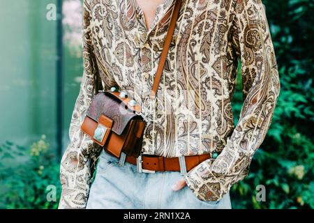 Milano, Italia - 19 giugno 2022: L'uomo indossa una borsa a spalla media della collezione Crown me e una camicia stampata con paisley di Etro, Street style. Foto Stock