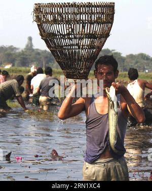 (150124) -- ASSAM, 23 gennaio 2015 -- Un uomo tribale mostra il suo pescato durante un evento di pesca comunitario come parte del festival Jonbeel vicino a Jagiroad, India, 23 gennaio 2015. Comunità e tribù come Tiwa, Karbi, Khasi e Jayantia dalle colline vicine scendono in gran numero per partecipare al festival e scambiare merci tramite baratto piuttosto che denaro. Durante questo festival si tengono anche combattimenti tra gruppi tribali e non tribali. INDIA-ASSAM-JAGIROAD-JONBEEL FESTIVAL Stringer PUBLICATIONxNOTxINxCHN Assam 23 gennaio 2015 un uomo tribale mostra la sua cattura durante Foto Stock