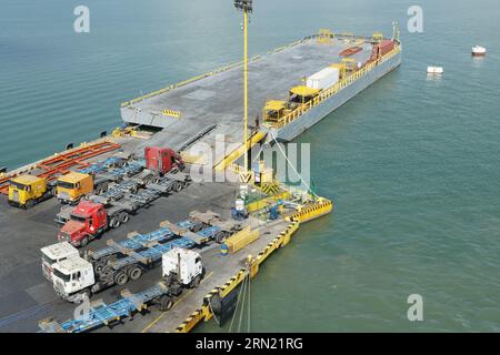 Camion e camion vuoti parcheggiati su un molo di carico accanto al pontone galleggiante come parte del terminal container di Puerto Barrios. Foto Stock