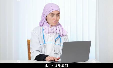 Praticante musulmano in hijab rosa lavora in una clinica privata Foto Stock