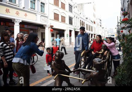 (150220) -- HAIKOU, 20 febbraio 2015 -- i turisti posano per le foto nella vecchia via Qilou di Haikou, capitale della provincia di Hainan della Cina meridionale, 20 febbraio 2015. La vecchia strada Qilou, una famosa strada con una storia di più di un secolo, caratterizzata da edifici a più piani in stile sud-est asiatico che integrano stili architettonici cinesi ed europei, è stata elencata come una delle famose strade storiche cinesi. Molte persone vengono qui il terzo giorno del loro Festival di Primavera. ) (Wjq) CHINA-HAINAN-HAIKOU-SPRING FESTIVAL (CN) GuoxCheng PUBLICATIONxNOTxINxCHN Haikou 20 febbraio 2015 i turisti si aspettano per le foto AL Foto Stock