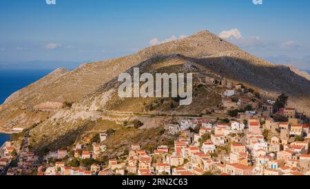 Isola di Symi, Grecia. Vacanze nelle isole della Grecia da Rodi nel Mar Egeo. Splendide case in stile neoclassico colorate sulle colline di un'isola greca durante il Foto Stock