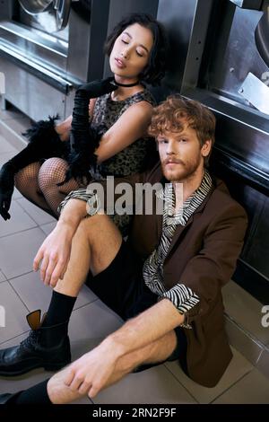 giovane asiatico alla moda uomo guardando a macchina fotografica vicino asiatico fidanzata in pubblico lavanderia Foto Stock