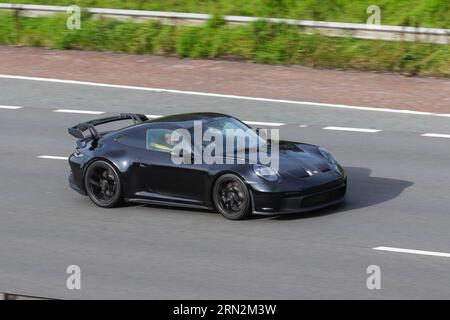 Porsche 911 997 Turbo coupé 2002 Black; viaggia a velocità sostenuta sull'autostrada M6 a Greater Manchester, Regno Unito Foto Stock