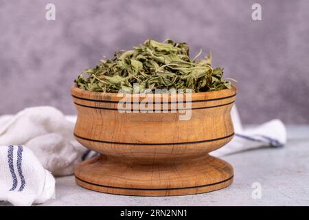 Tè di balsamo essiccato. Foglie di tè al balsamo al limone essiccate al sole in un recipiente di legno. erboristeria Foto Stock