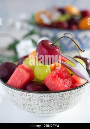 tazza con acqua fredda e frutta fresca estiva con ghiaccio Foto Stock