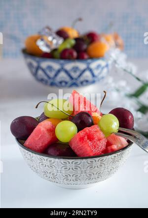 tazza con acqua fredda e frutta fresca estiva con ghiaccio Foto Stock