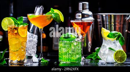 Cocktail alcolici con gin, whisky, vermouth e liquori, sfondo nero bar, atmosfera notturna Foto Stock