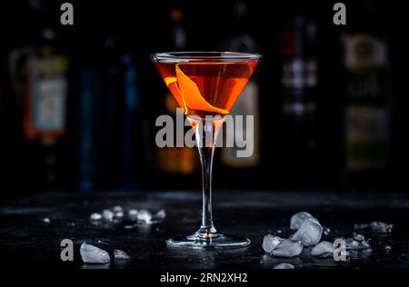 Bobby Burns forte cocktail drink con whisky scotch, vermouth e liquore in un bicchiere di martini, sfondo scuro da bar Foto Stock