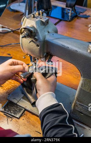 Francia, Aveyron, Millau, Maison Fabre (Ganterie Fabre), fabbrica di guanti a conduzione familiare fondata nel 1924, tecnica inglese di cucito dei guanti su vecchie macchine in officina Foto Stock