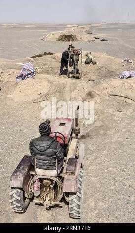 TURPAN, 2015 -- l'operaio di dragaggio Ablimit Yagufu e i suoi membri della famiglia cercano di dragare un pozzo di karez a Turpan, nella regione autonoma dello Xinjiang Uygur della Cina nordoccidentale, 3 aprile 2015. I pozzi karez sono pozzi verticali e canali sotterranei che si estendono sotto forma di fossati e piccoli stagni. Il sistema di irrigazione karez, composto da pozzi verticali, canali sotterranei e sotterranei e piccoli bacini, fu costruito 2.000 anni fa ed è considerato una delle più grandi strutture artificiali antiche della Cina sopravvissute, insieme alla grande Muraglia e al Canal grande. Turpan, il regio più caldo e asciutto Foto Stock