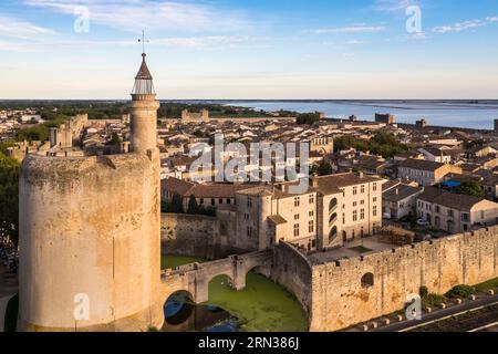 Francia, Gard, Aigues Mortes, la città medievale circondata dai suoi bastioni, la Torre di Costanza in primo piano e le saline (Salins du Midi) sullo sfondo (vista aerea) Foto Stock