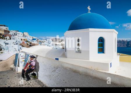 Grèce, l'arcipelago delle Cicladi, l'isola di Santorin, il villaggio di Oia, il musicista Foto Stock