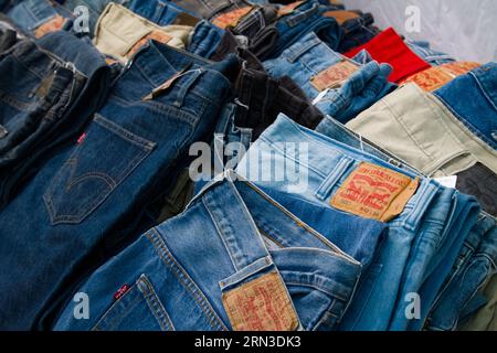 Jeans in denim Levis Strauss d'epoca piegati in vendita su Uno stallo del mercato dell'abbigliamento Vintage, Inghilterra, Regno Unito Foto Stock