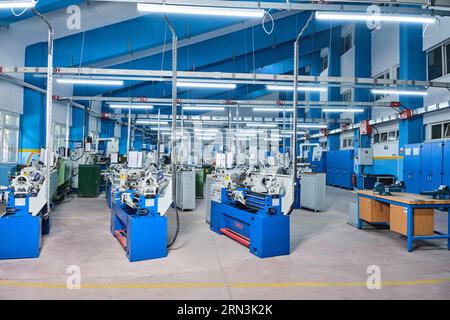 molti macchinari industriali identici in una fabbrica. attrezzature di una fabbrica/officina. macchine industriali ad alta tecnologia. officina automatizzata Foto Stock