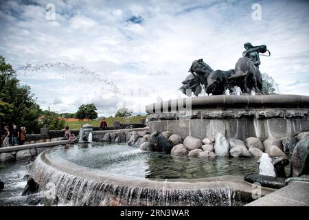 Gefion Fountain Sculpture Langelinie Promenade Copenhagen // COPENHAGEN, Danimarca — la fontana Gefion si trova all'ingresso della passeggiata di Langelinie. La grande scultura in bronzo raffigura la dea norrena Gefjon e i suoi quattro buoi, arando drammaticamente il mare in mezzo a getti d'acqua, illustrando la mitica creazione della Zelanda. Foto Stock