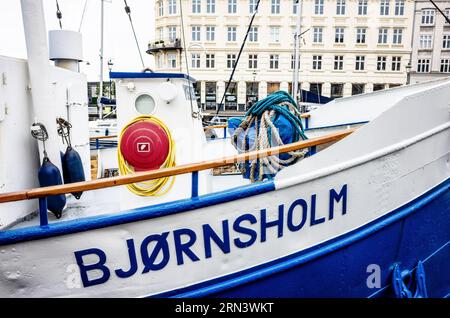 COPENAGHEN, Danimarca — la nave Bjornsholm attraccata a Nyhavn. Nyhavn, lo storico porto di Copenaghen, è visto animato da attività. Un tempo porto commerciale dove attraccavano navi da tutto il mondo, Nyhavn è ora un luogo di ritrovo culturale pieno di ristoranti, bar e case tradizionali, segnando la sua trasformazione da vivace centro marittimo a principale attrazione turistica. Foto Stock