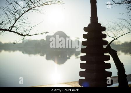 WASHINGTON DC - rami di ciliegio in erba incorniciano una vista della Pagoda giapponese e del Jefferson Memorial attraverso il bacino delle maree all'inizio della primavera. La pagoda di pietra, un dono del sindaco di Yokohama nel 1957, si trova vicino ai famosi ciliegi fioriti, che furono donati dal Giappone nel 1912. Foto Stock