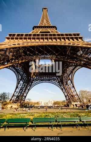 Vista della base della Torre Eiffel Parigi Francia // PARIGI, Francia - la Torre Eiffel si innalza nel cielo, vista dalla sua base in una giornata di sole. L'iconica struttura a reticolo in ferro battuto, simbolo di Parigi, si estende verso l'alto, mostrando il suo complesso design architettonico. Foto Stock