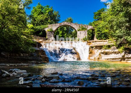 Il ponte medioevale di Ponte della Brusia sul fiume Montone e la cascata di Bocconi in Emilia-Romagna, Italia Foto Stock