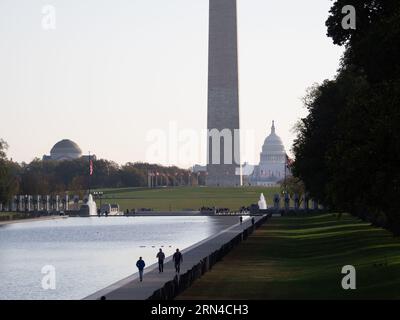 WASHINGTON DC, Stati Uniti: Il monumento a Washington si riflette nelle acque calme della piscina riflettente all'alba. La luce del mattino presto inonda il National Mall di un caldo bagliore, evidenziando l'iconico obelisco e creando una scena serena e pittoresca. Il Washington Monument, uno dei monumenti più riconoscibili degli Stati Uniti, è un tributo al primo presidente della nazione, George Washington. Foto Stock