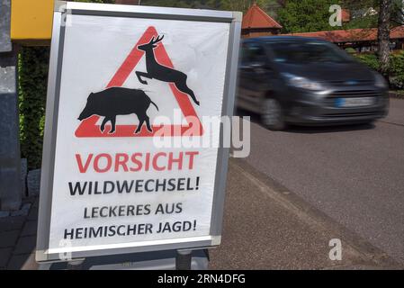 Poster attenzione attraversamento cervi su Dorfstr. Di fronte ad un ristorante, Freiamt, Foresta Nera, Baden-Wuerttemberg, Germania Foto Stock