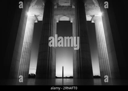Colonne del Lincoln Memorial all'alba, Washington, D.C. fotografia in bianco e nero che mostra una vista dall'interno del memoriale, guardando verso il monumento a Washington. Foto Stock