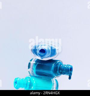 smalto per unghie con sfumature blu ravvicinate grazie al flacone aperto sovrapposto Foto Stock