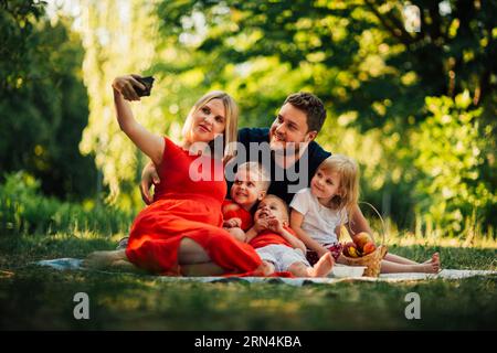 Mamma che fa selfie di famiglia all'aperto Foto Stock