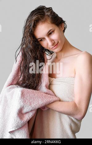 Ritratto donna che asciuga i capelli con un asciugamano Foto Stock