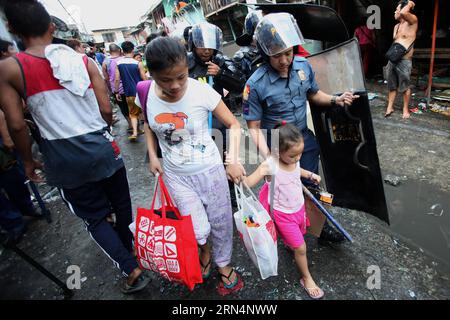AKTUELLES ZEITGESCHEHEN Philippinen: Ausschreitungen bei Räumung und Abriss eines Armenviertels (150526) -- CALOOCAN CITY, 26 maggio 2015 -- Un poliziotto aiuta una donna e una ragazza mentre le squadre di demolizione smantellano le baraccopoli a Caloocan City, Filippine, 26 maggio 2015. Quattro persone sono rimaste ferite mentre altre due sono state arrestate dopo che i residenti si sono scontrati con le autorità. 500 famiglie sono state lasciate senza tetto nella demolizione della zona baraccopoli. ) FILIPPINE-CALOOCAN CITY-SLUM AREA DEMOLITION RouellexUmali PUBLICATIONxNOTxINxCHN News eventi attuali Filippine Riots at Clearance and Demolition a Poor di Foto Stock