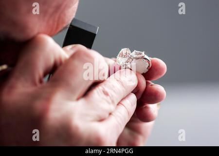 Controllare un anello con una pietra preziosa per l'autenticità Foto Stock