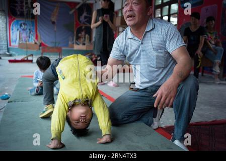 (150531) -- HEFEI, 31 maggio 2015 -- foto scattata il 26 maggio 2015 mostra Luan Haohao di cinque anni che fa esercizi acrobatici sotto la guida dell'insegnante Miu Honghu in una scuola di acrobazie nel villaggio di Sanwang, nella contea di Yingshang nella provincia di Anhui della Cina orientale. Fondata nel 2007, la scuola di acrobazie nel villaggio di Sanwang iscrive più di un centinaio di bambini ogni anno, che imparano acrobazie per guadagnarsi da vivere. ) (Zwx) CHINA-ANHUI-YINGSHANG-CHILDREN-ACROBATICS(CN) GuoxChen PUBLICATIONxNOTxINxCHN 150531 Hefei maggio 31 2015 la foto scattata IL 26 2015 maggio mostra Luan Haohao di cinque anni che svolge esercizi acrobatici Foto Stock