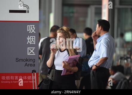 (150601) -- PECHINO, 1 giugno 2015 -- le persone fumano in un'area fumatori all'esterno del Terminal 3 dell'Aeroporto Internazionale Capital di Pechino, capitale della Cina, 1 giugno 2015. Un nuovo divieto di fumo è entrato in vigore a Pechino il 1° giugno. Il nuovo divieto, il più duro del paese fino ad oggi, proibisce il fumo in tutti i luoghi pubblici al coperto, nei luoghi di lavoro e sui mezzi pubblici della città. A seguito del divieto, l'aeroporto della capitale lunedì ha chiuso tre sale fumatori nei suoi tre terminal e ha aperto 11 spazi fumatori all'esterno. (wf) CHINA-BEIJING-SMOKING BAN (CN) LuoxXiaoguang PUBLICATIONxNOTxINxCHN 150601 Pechino 1 giugno 2 Foto Stock