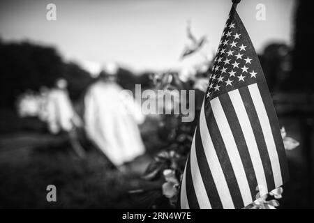 Bandiera americana al Korean War Veterans Memorial, Washington D.C. la fotografia in bianco e nero mostra la bandiera in primo piano con le statue dei soldati sfocate sullo sfondo. Foto Stock