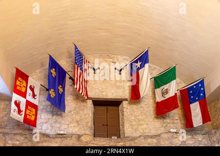 San Antonio, Texas, Stati Uniti d'America – 7 maggio 2023: Interno dell'Alamo a San Antonio con una mostra delle sei storiche bandiere del Texas. Foto Stock