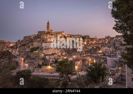 Cattura il fascino di Matera, Italia, dopo il tramonto con questa incantevole fotografia. La scena notturna rivela l'accattivante paesaggio urbano di Matera Foto Stock