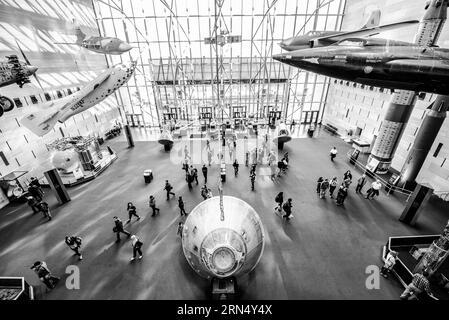 WASHINGTON DC, USA - foto in bianco e nero da una vista sopraelevata del foyer principale all'interno dell'ingresso del National Air and Space Museum dello Smithsonian Institution sul National Mall di Washington DC. il modulo lunare nella parte inferiore della cornice è il veicolo di rientro originale dell'Apollo XI, mentre l'aereo arancione in alto a sinistra era l'aereo Bell X-1 di Chuck Yeager in cui ruppe la barriera sonora per la prima volta in volo di livello. Il Museo dell'aria e dello spazio, che si concentra sulla storia dell'aviazione e dell'esplorazione spaziale, è uno dei musei più visitati al mondo. Foto Stock