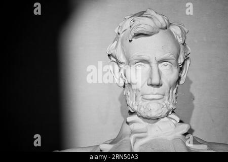 WASHINGTON, DC--intorno al tempo dell'equinozio di caduta e di primavera, con il sole che sorge direttamente in th est durante quel tempo, il sole che sorge brilla direttamente sulla statua di Abraham Lincoln all'interno del Lincoln Memorial. Situato all'estremità occidentale del National Mall di Washington DC e accanto alla piscina riflettente che si affaccia sul Campidoglio degli Stati Uniti, il Lincoln Memorial è stato dedicato nel 1922 ed è uno dei più famosi luoghi di interesse di Washington DC. La grande statua in marmo di Abraham Lincoln che si trova all'interno è stata progettata da Daniel Chester French e scolpita dai fratelli Piccirilli. Foto Stock