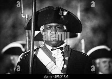 Old Guard Soldier, Joint base Myer-Henderson Hall, Arlington, Virginia - foto in bianco e nero / Old Guard Soldier presso Joint base Myer-Henderson Hall, Arlington. Fotografia in bianco e nero che mostra il soldato in uniforme tradizionale, tenendo in mano un moschetto, con altri soldati sullo sfondo. Foto Stock