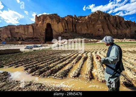 (150612) - KABUL, 12 giugno 2015 - Un contadino lavora vicino al luogo in cui si trovava il Buddha di Bamyan nella provincia di Bamyan, Afghanistan centrale, 7 giugno 2015. Una coppia cinese, e Liang Hong, hanno proiettato con successo l'immagine del Buddha più alto nella Valle di Bamyan il 6 e 7 giugno, utilizzando le più recenti tecnologie a misura di reliquie culturali, suscitando il plauso della gente del posto. I due Buddha Bamyan sono stati bombardati e distrutti a terra dai talebani nel 2001, nonostante gli appelli della comunità internazionale). AFGHANISTAN-BAMYAN-BAMYAN BUDDHA-PROIEZIONE IMMAGINE ZHANGXXINYU PUBLICATIONXNOTXINXCHN 150612 Foto Stock